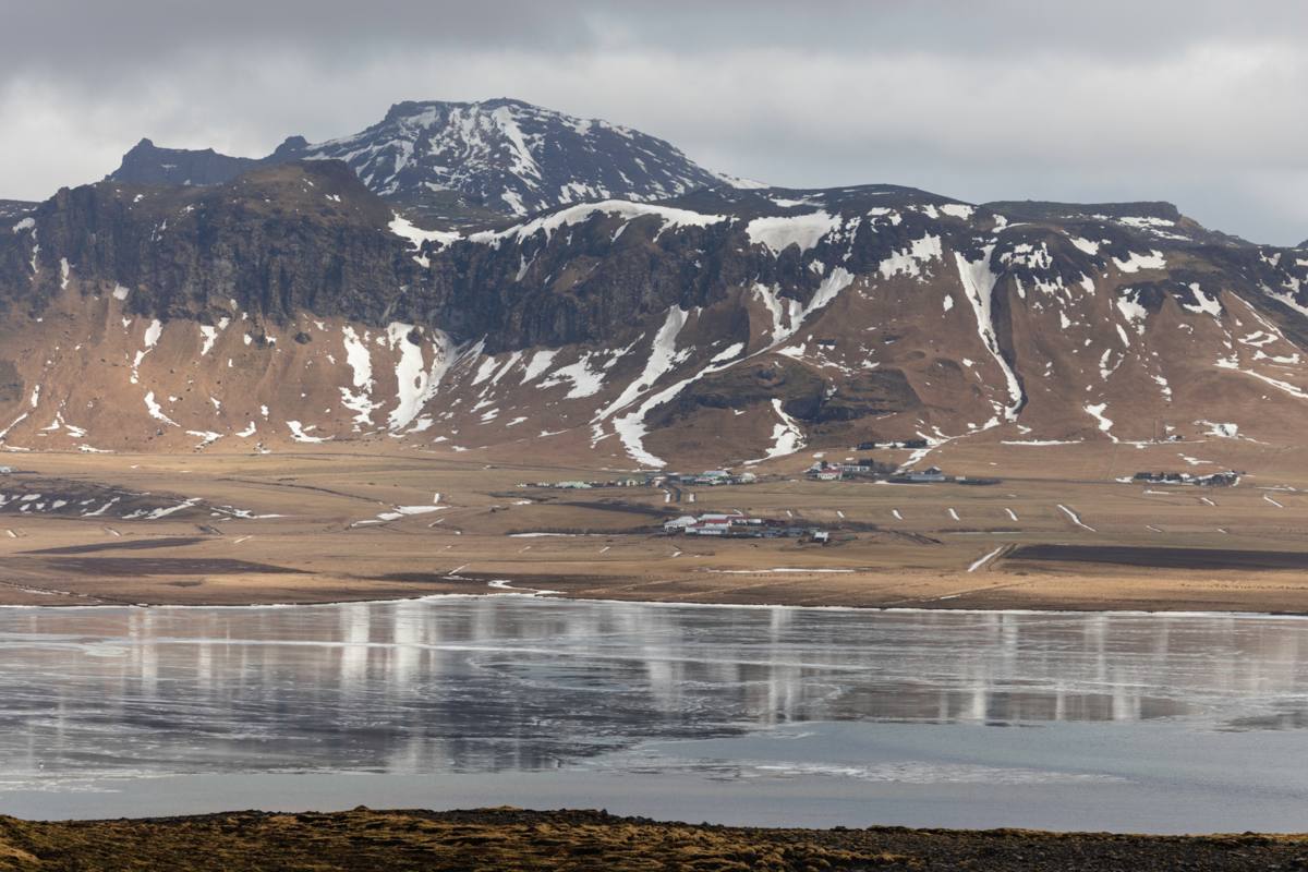 Kale berg met wat sneeuw en reflectie in water